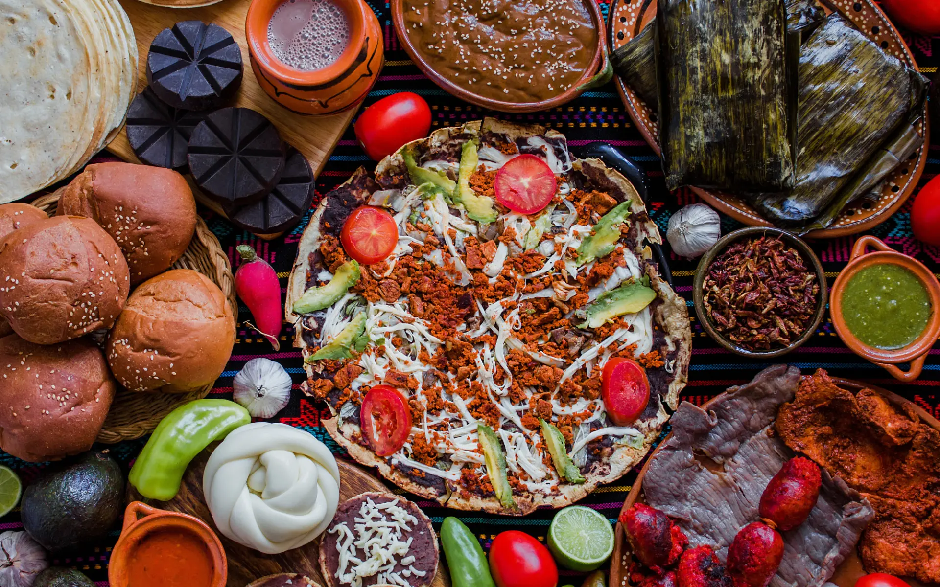 Mesa con tlayudas, chocolate, tamales y sabores tradicionales de Oaxaca