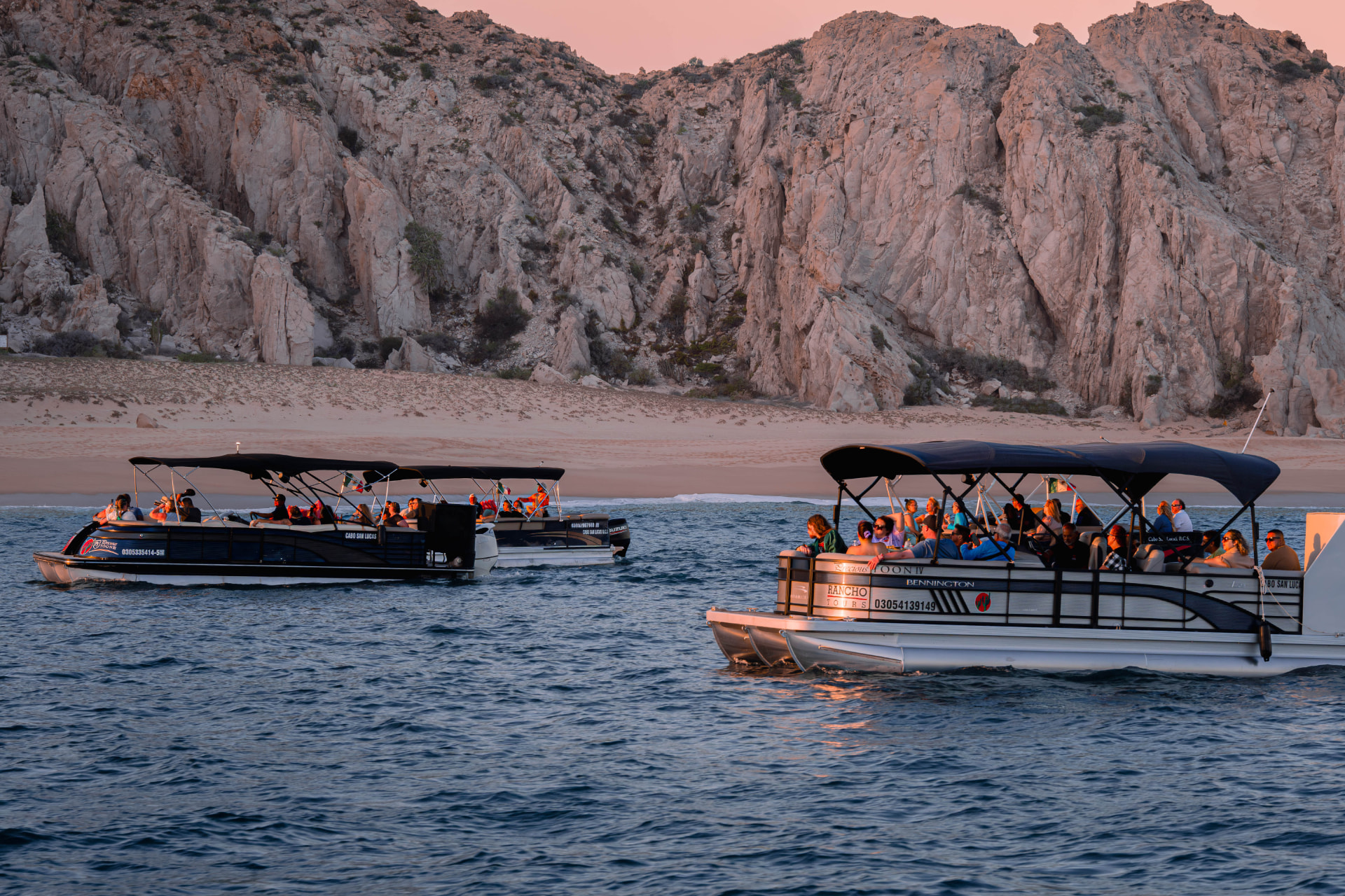 Embarcaciones navegando frente a la costa rocosa de Los Cabos