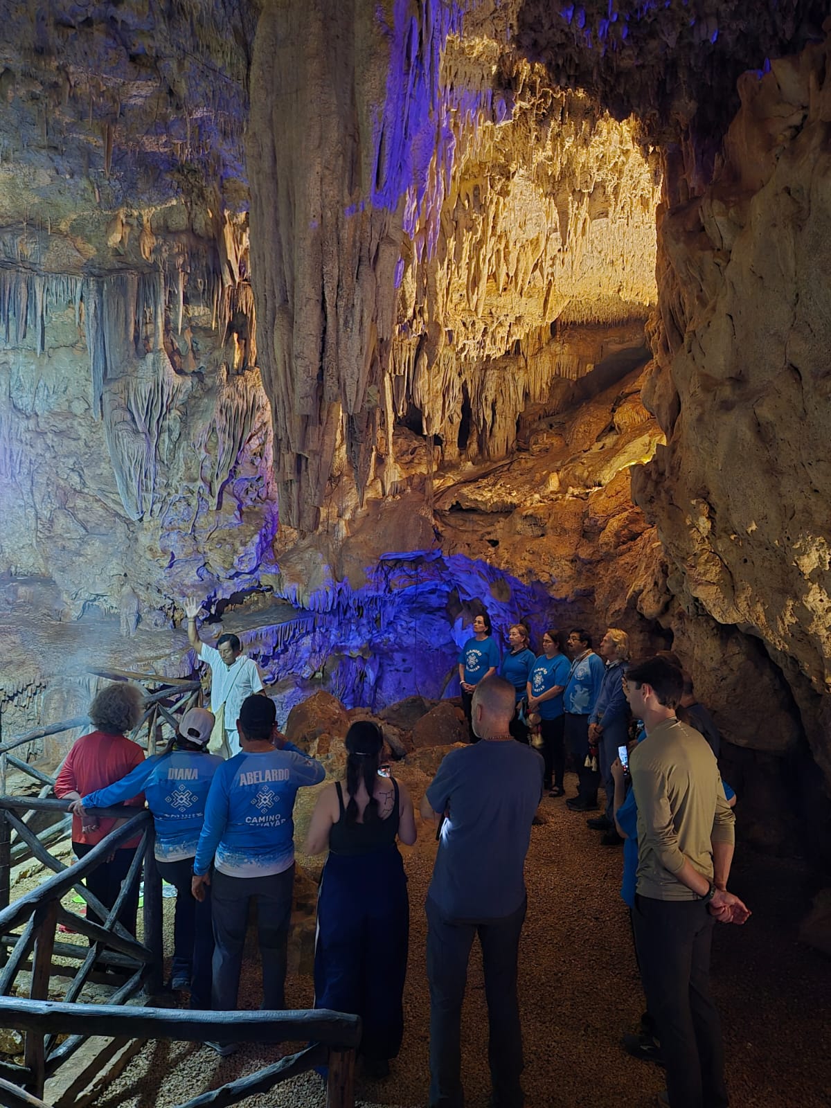 Grupo de viajeros dentro de una gruta iluminada con estalactitas en Yucatán