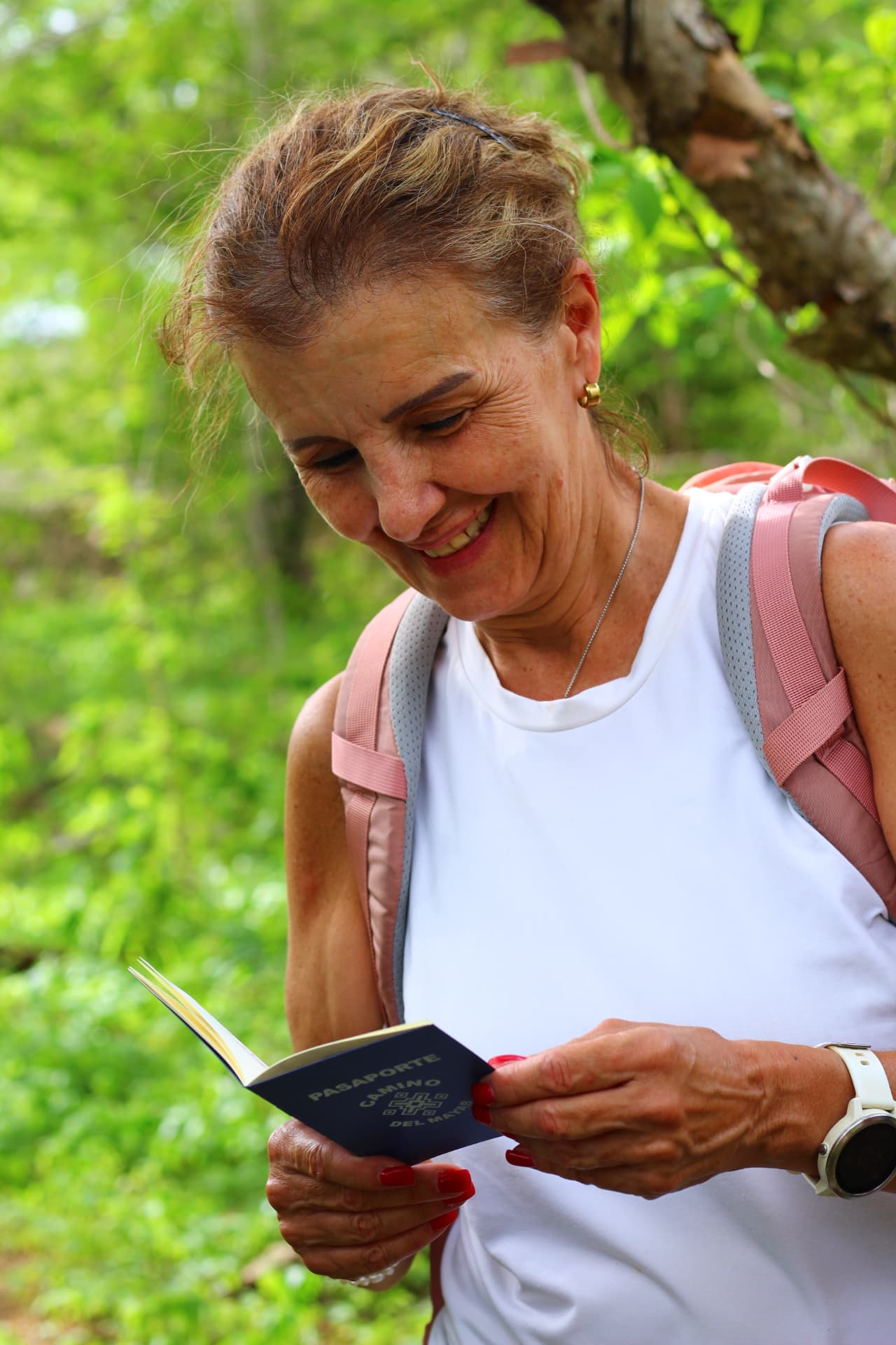 Viajera sonriente leyendo el Pasaporte Camino del Mayab durante la caminata